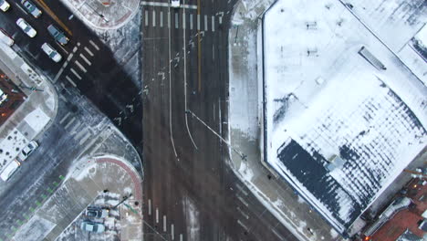 Aerial-cinematic-drone-birds-eye-view-looking-down-downtown-Denver-Colorado-city-buildings-snowing-freezing-cold-winter-day-gray-bird-dramatic-city-landscape-forward-follow-snowy-roads