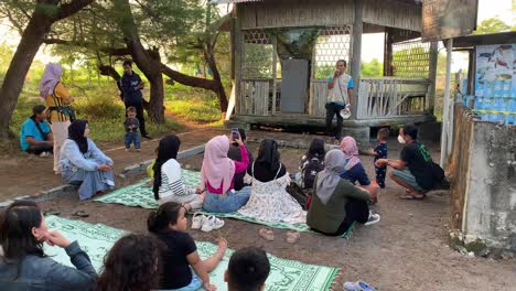 Indonesia---Jul-9,-2023-:-parents-and-their-children-listening-to-instructions-from-hatchling-release-officers-at-Goa-Cemara-Beach,-Yogyakarta
