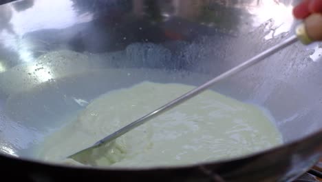 close-up-scene-in-which-a-person-is-mixing-the-A2-milk-on-a-pan-with-a-whisk-very-well-to-make-the-product-saffron-rich-and-quality