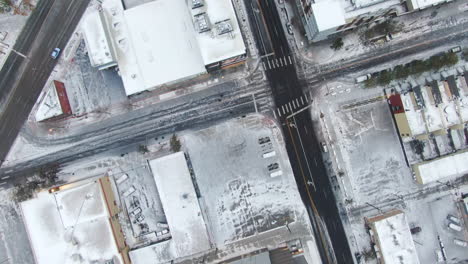Aerial-cinematic-drone-birds-eye-view-looking-down-downtown-Denver-Colorado-city-buildings-snowing-freezing-cold-winter-day-gray-bird-dramatic-city-landscape-car-traffic-passing-forward-movement