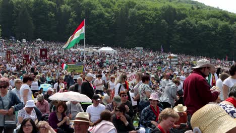 People-holding-flags,-signs,-some-eating,-wait-for-start-of-Csiksomlyo-Pilgrimage