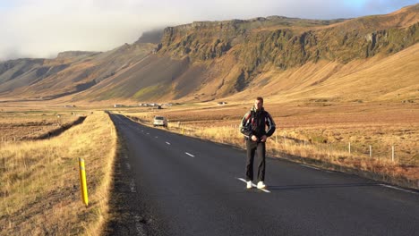 Un-Joven-Caucásico-Camina-Por-Un-Camino-En-El-Paisaje-Natural-De-Montaña-En-Islandia,-País-Nórdico