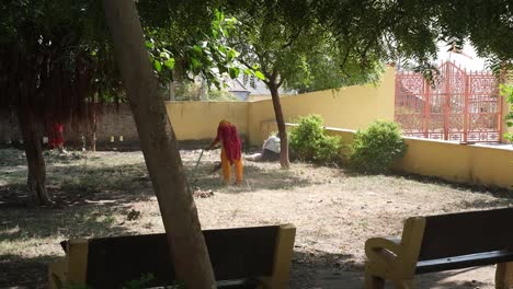 Una-Gran-Cantidad-De-Basura-Debajo-De-Un-árbol-En-Las-Instalaciones-De-Un-Templo-Está-Siendo-Removida-Y-Limpiada-Por-Trabajadoras-De-Una-Ong