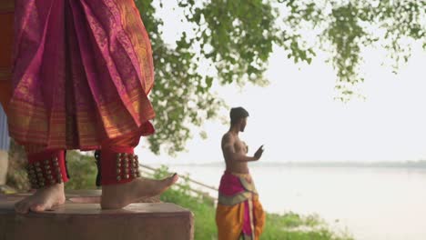 Zwei-Tänzer-Tanzen-Klassischen-Indischen-Tanz-Bharatnatyam,-Fußbewegung,-Männlicher-Tänzer-Tanzt-Im-Hintergrund-In-Zeitlupe