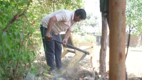Young-NGO-worker-is-shoveling-plastic-waste-with-his-hand-and-cleaning-the-place
