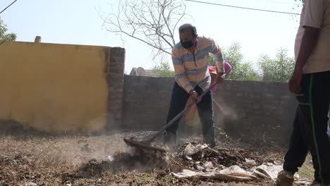 Escena-Desde-El-Frente-De-Un-Sitio-Religioso-Donde-La-Basura-Y-Los-Desechos-Plásticos-Se-Retiran-Y-Limpian-A-Mano-Y-Con-La-Ayuda-De-Herramientas