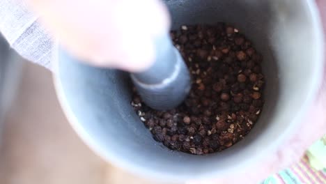 Scene-from-above-in-which-a-person-is-grinding-pepper-masala-with-the-help-of-Dasta-who-is-making-a-powder-from-this-pepper-masala-with-the-help-of-hands