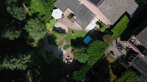 A-young-little-girl-doing-a-handstand-exercise-in-the-backyard-of-her-home,-Top-down-aerial-shot