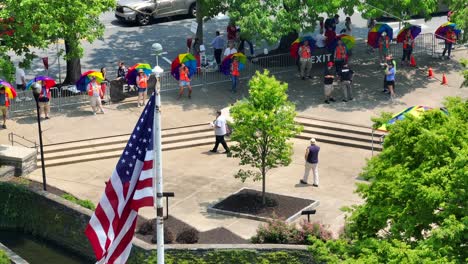 Luftaufnahme-Von-Wachen-Mit-Reflektierender-Weste-Und-Regenbogenschirm-Während-Des-LGBT-Pride-Festivals-In-Einer-Amerikanischen-Stadt