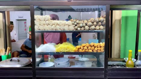 Woman-preparing-meatball-dish-or-"bakso"-with-roadside-stall