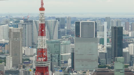 Die-Obere-Hälfte-Des-Tokyo-Tower,-Gefilmt-Vom-Dach-Des-Mori-Tower,-Mit-Hochhäusern-Im-Hintergrund
