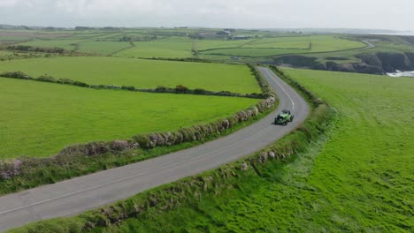 Vintage-rally-car-driving-on-the-stunning-Copper-Coast-Drive-Waterford-Ireland-early-on-a-summer-morning