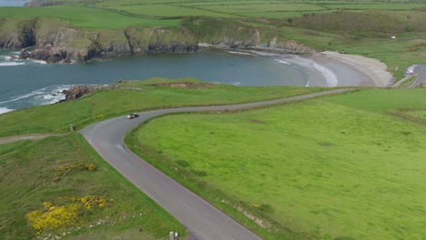 Vista-Espectacular-De-Kilmurrin-Cove-Costa-De-Cobre-Waterford-Irlanda-Con-Un-Coche-Clásico-En-Un-Rally-A-Principios-De-Verano