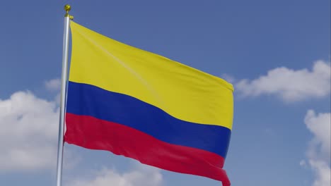 Flagge-Kolumbiens-Bewegt-Sich-Im-Wind-Mit-Einem-Klaren-Blauen-Himmel-Im-Hintergrund,-Wolken-Bewegen-Sich-Langsam,-Fahnenmast,-Zeitlupe