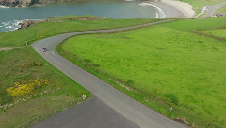 Classic-car-going-down-to-spectacular-Kilmurrin-cove-Waterford-Ireland-on-a-bright-summer-day