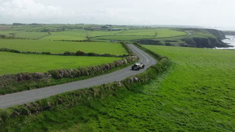 Happy-drivers-on-a-rally-in-their-vintage-car-on-the-Copper-Coast-Drive-Waterford-Ireland-on-a-summer-morning