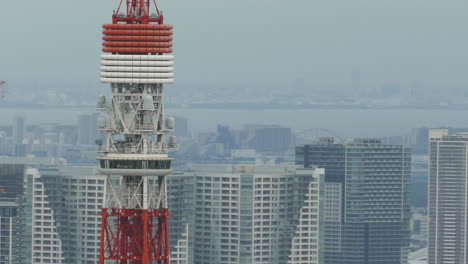 Die-Obere-Aussichtsplattform-Des-Tokyo-Tower,-Gefilmt-Vom-Dach-Des-Mori-Tower,-Mit-Hochhäusern-Im-Hintergrund