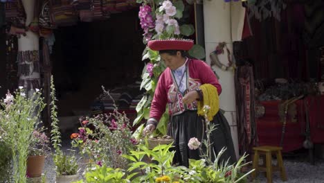 Una-Mujer-Joven-Con-Un-Sombrero-Colorido-Tradicional-Peruano-Y-Un-Atuendo-Mientras-Mira-Artículos-En-Una-Canasta