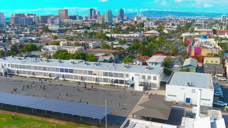 Overhead-flyby-of-a-schoolyard-in-Long-Beach-California-|-Afternoon-lighting-|-View-of-downtown-in-background