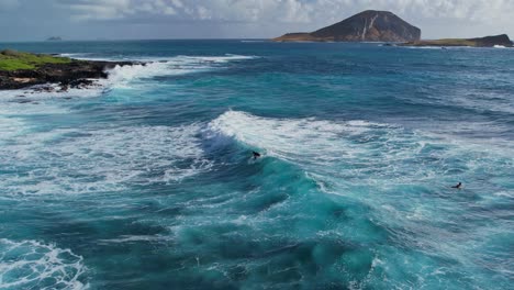 Surfer-riding-dramatic-turquoise-wave-in-slow-motion-on-a-clear-morning-in-Oahu-HI