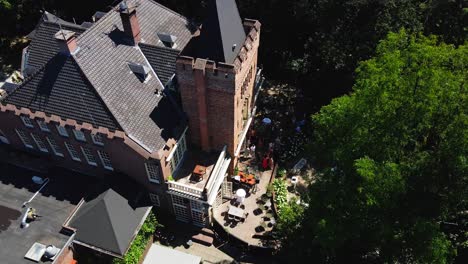 Aerial-of-a-wedding-party-in-front-of-a-beautiful-manor-on-a-nice-summer-day