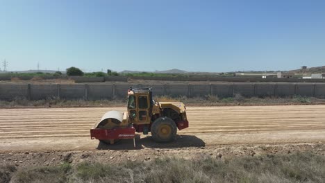 Dynapac-Soil-Compactor-Moving-Across-Ground-In-Rural-Pakistan