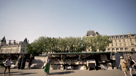 Vintage-Bücher-Und-Kunsthändler-Vor-Der-Seine-Und-Dem-Louvre-Palast-Mit-Passanten,-Blick-Vom-Fahrzeug-Aus