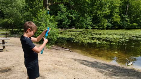 4K-60FPS-Happy-Boy-is-Blowing-Soap-Bubbles-next-to-Forest-Lake-in-Denmark