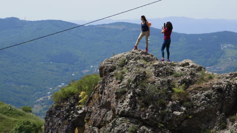 Excursionistas-Femeninas-En-El-Pico-De-La-Montaña-Rocosa-Admirando-El-Paisaje-En-El-Campo-De-Georgia