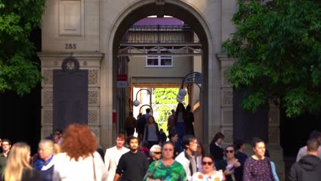 Static-shot-capturing-busy-lunch-time-rush-hours,-large-crowds-of-office-workers-crossing-GPO-laneway-between-Queen-and-Elizabeth-street-with-the-archway-of-heritage-listed-buildings-in-the-background
