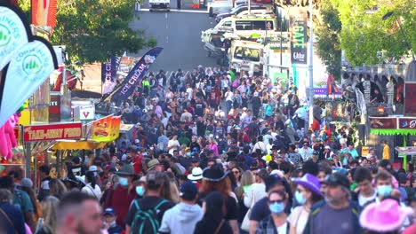 Massive-swarm-of-crowds-at-iconic-Ekka-annual-agricultural-exhibition,-Royal-Queensland-Show-on-Gregory-Terrace-outdoor-festival-and-carnival-rides-and-games-at-Brisbane-Showgrounds,-Bowen-Hills