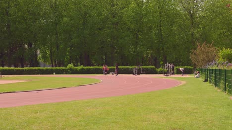 Gente-Disfrutando-De-Actividades-Físicas-Con-Equipos-De-Gimnasio-Al-Aire-Libre-En-El-Campo-Deportivo-Del-Parque-Cincuentenario-En-Bruselas,-Bélgica