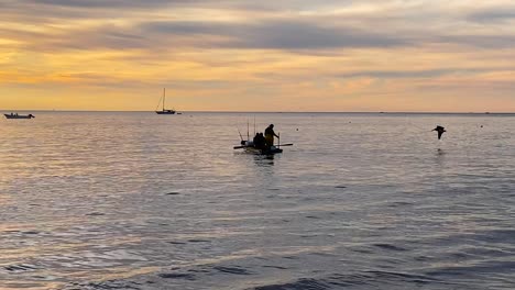 Aufnahme-Einer-Gruppe-Von-Fischern,-Die-Bei-Sonnenaufgang-Ein-Ruderboot-Gegen-Die-Ebbe-Rudern,-Um-In-Bahia-Asuncion,-Mexiko,-Fische-Zu-Fangen