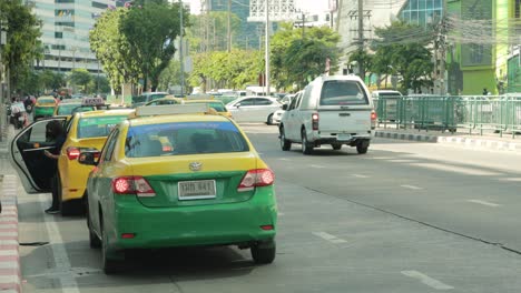 Thailändische-Taxis-Parken-Am-Rand-Einer-Stark-Befahrenen-Straße-In-Bangkok,-Thailand