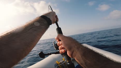 La-manga,-Murcia,-Spain,-July-10,-2023:-Fisherman-reeling-in-fish-from-zodiac-at-mediterranean-sea