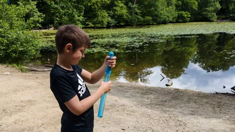 4K-60FPS-Young-Boy-is-Blowing-Soap-Bubbles-Outdoors-in-Denmark,-Scandinavia