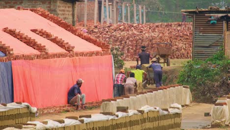 Trabajadores-Asiáticos-De-Hornos-De-Ladrillos-Que-Transportan-Ladrillos-De-Arcilla-En-Una-Carretilla-Con-Ruedas-En-Las-Zonas-Rurales-De-Bangladesh