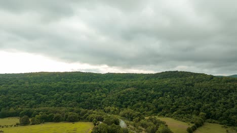 Wolkenlandschaft-über-Dickichtwald-Mit-Einer-Brücke-Und-Fließendem-Fluss-In-Lancaster,-Arkansas,-USA