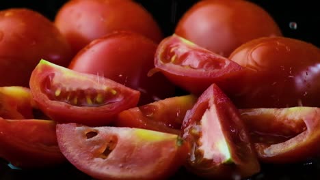 Zeitlupenaufnahme-Von-In-Viertel-Geschnittenen-Roten-Tomaten,-Die-Mit-Wasser-Bespritzt-Sind