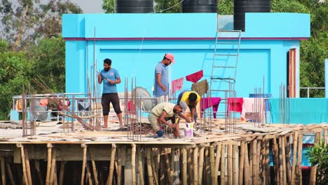 Construction-workers-working-on-a-building-roof-in-Bangladesh