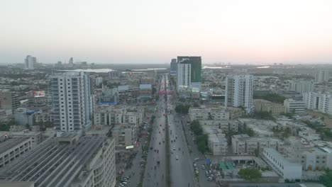 Aerial-drone-footage-of-busy-city-streets-and-sprawling-landscape-in-Punjab-Chowrangi,-Karachi,-Pakistan
