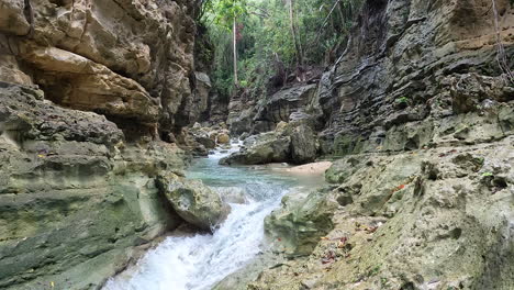 Deep-natural-gorge-with-fresh-river-stream-flowing-in-bottom---Static-slow-motion-aerial-Philippines