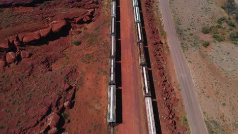 Aerial-view-tilting-over-trains-parked-at-a-desert-station,-in-Southwest-USA