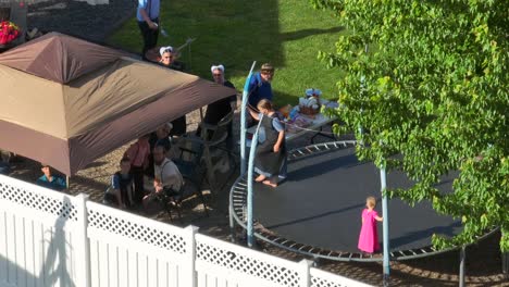 Amish-family-enjoying-barbeque-party-and-trampoline-in-backyard,aerial