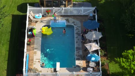 Familia-Disfrutando-De-Una-Fiesta-En-La-Piscina-Del-Patio-Trasero,-Vista-Aérea-De-EE.UU.