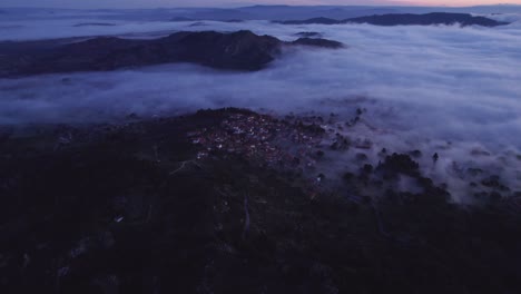 Kippaufnahme-Des-Touristischen-Dorfes-Monsanto-Portugal-Mit-Niedrigem-Nebel,-Luftaufnahme