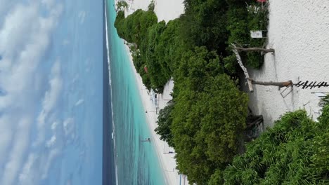 Perfect-tropical-island-Paradise-on-Dhigurah-island-sandbank-with-its-volleyball-court-on-long-white-sand-beach-amid-pristine-turquoise-water-and-lush-vegetation