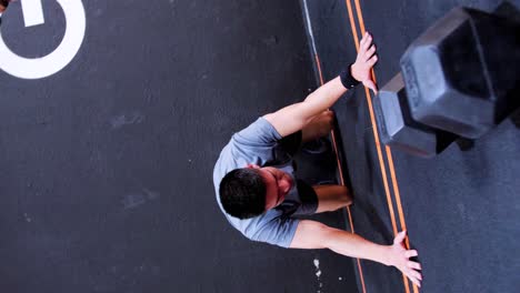 Una-Foto-De-Un-Joven-Caucásico-En-Medio-De-Una-Sesión-De-Crossfit-En-Un-Gimnasio,-Escalando-Una-Pared-Con-Las-Piernas