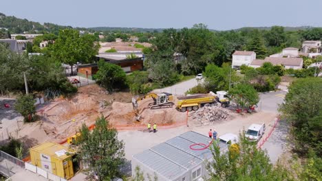 Luftaufnahme-Eines-Bulldozers,-Der-Sand-Gräbt-Und-Ihn-Auf-Einer-Baustelle-In-Den-LKW-Legt