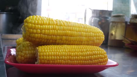 Close-up-scene-of-steaming-hot-sweet-corn-filled-in-a-dish-with-hot-steam-coming-out-of-the-hot-American-sweet-corn